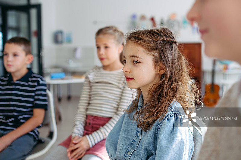 孩子们在上课前，和老师一起坐在晨圈里。图片素材