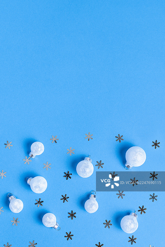 蓝色背景上的白色圣诞球和银色雪花，极简圣诞装饰图片素材
