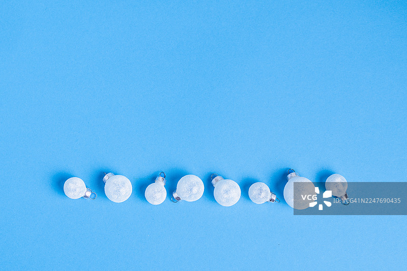 冬季装饰线条，带有磨砂白珠，背景为蓝色图片素材