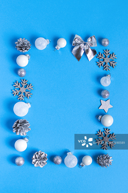 垂直圣诞节相框，背景为蓝色，饰有白色和银色装饰品图片素材