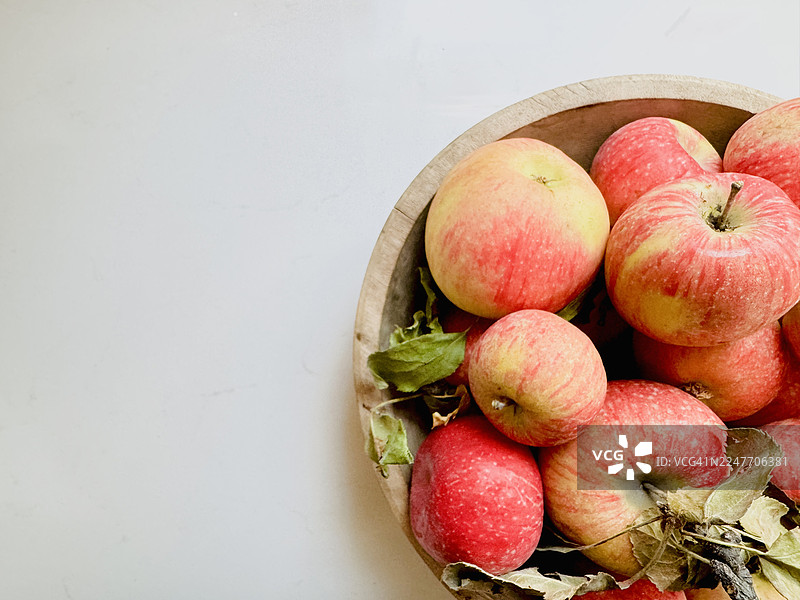 质朴的木碗里盛着新鲜的苹果，俯视角度，留有复制空间图片素材