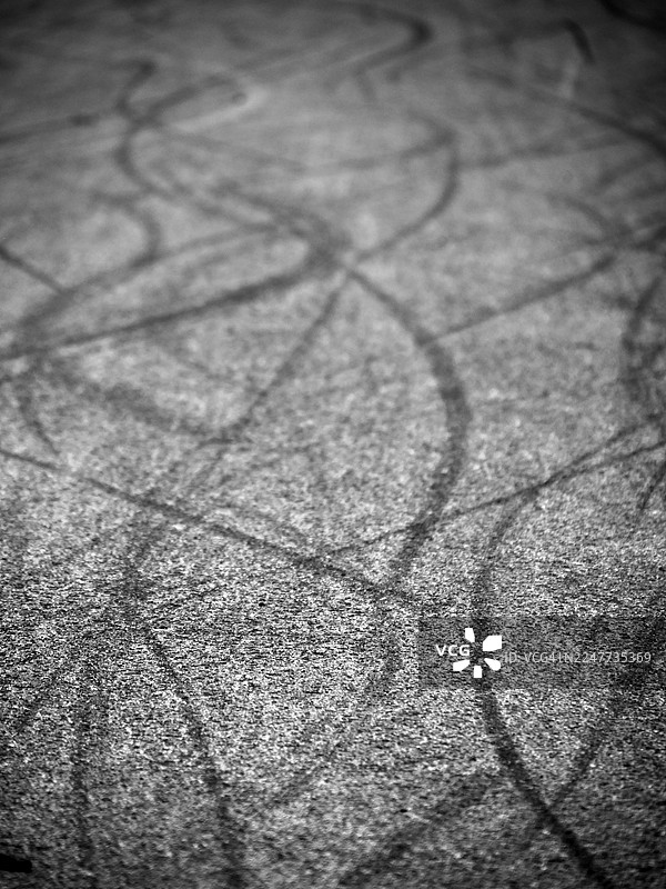 英国伦敦道路上的刹车痕迹特写，有阳光和阴影。黑白。图片素材
