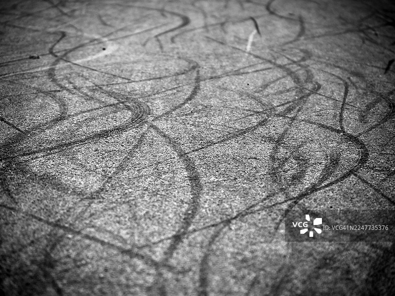 英国伦敦街道上轮胎痕迹的特写。阳光与阴影。黑白。图片素材