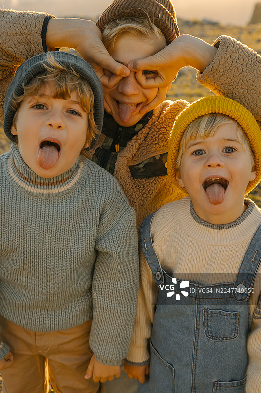 三个穿着舒适冬装的朋友在户外嬉戏，逗弄着镜头图片素材