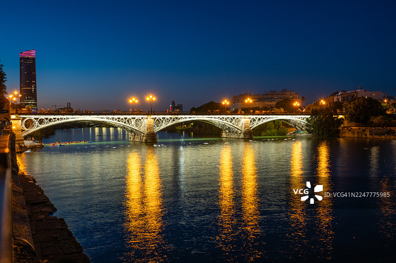 西班牙塞维利亚的瓜达尔基维尔河与特里亚纳桥的黄昏景色图片素材