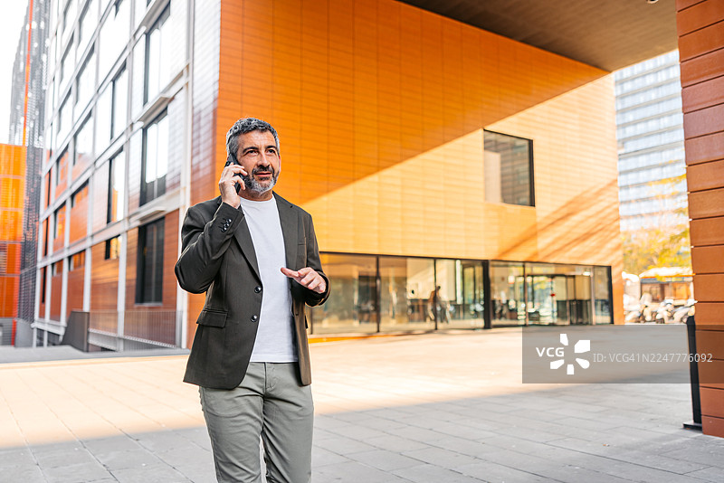 一位成熟的男士在西班牙巴塞罗那街头边走边打电话图片素材