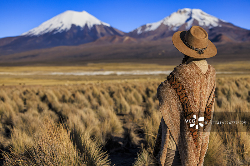 一位女性游客正在眺望玻利维亚的帕里纳科塔火山图片素材