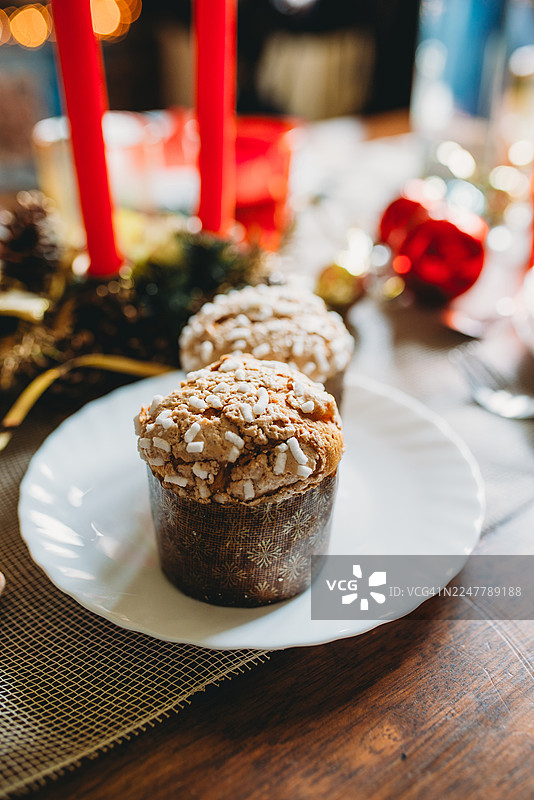 圣诞晚餐庆祝活动中，白盘上放着两个潘多罗蛋糕图片素材