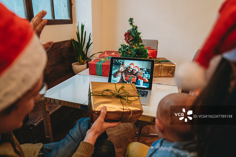 家人通过视频通话向朋友展示圣诞礼物，进行线上庆祝图片素材