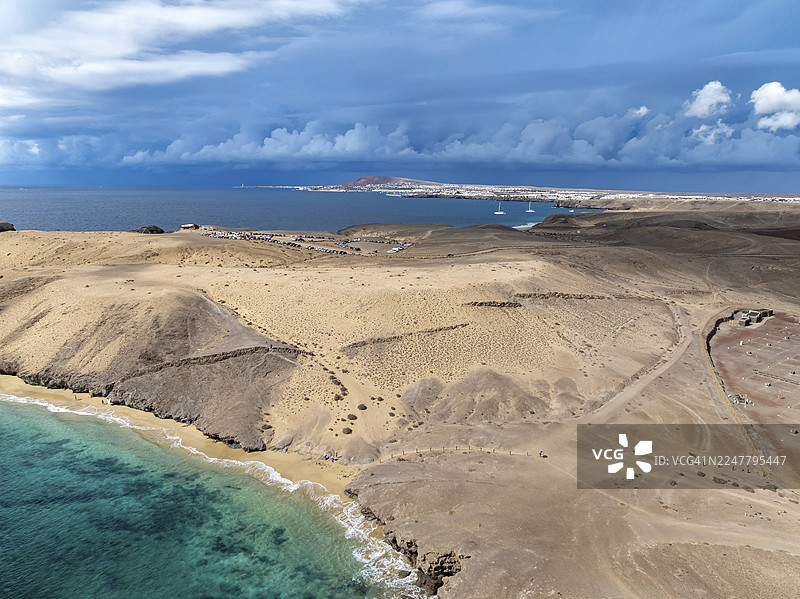 西班牙加那利群岛兰萨罗特岛洛斯阿哈切斯自然公园的海岸,拥有平坦的康格里奥海滩和蔚蓝大海,以及干旱的景观,俯瞰图图片素材