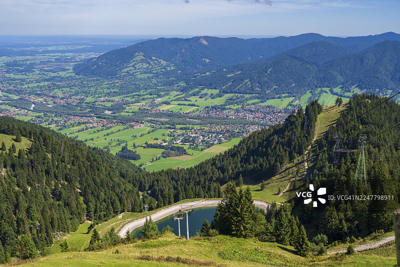 从布劳内克山（Brauneck）眺望莱恩格里斯（Lenggries），前景为水库，背景为巴伐利亚前阿尔卑斯山、伊萨尔文克尔地区、莱恩格里斯、上巴伐利亚、巴伐利亚、德国图片素材