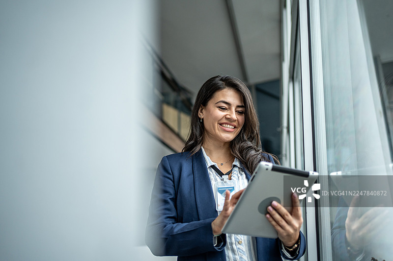 快乐的女商人正在使用平板电脑工作图片素材