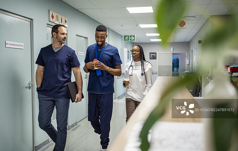 医疗团队在医院走廊里讨论医疗保健问题图片素材