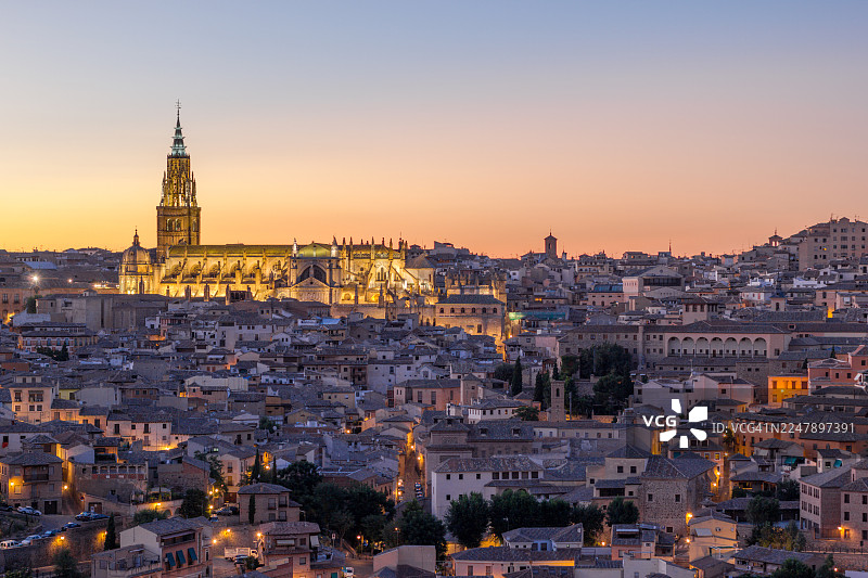 西班牙托莱多黄昏时分的城市景观，有灯火辉煌的大教堂图片素材