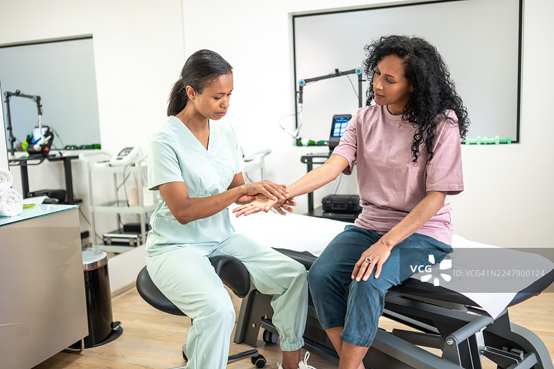 理疗师在临床环境中检查患者手腕图片素材