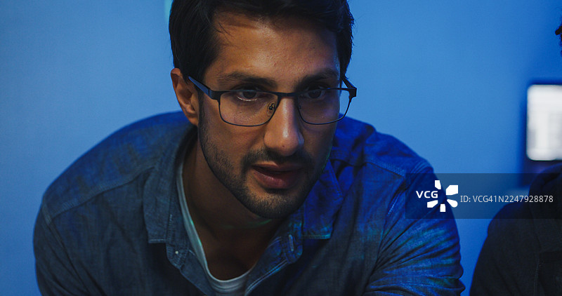 特写：黑人和西班牙裔男性工程师程序员在科技办公室深夜协作，讨论软件开发策略。软件开发人员，人工智能。图片素材