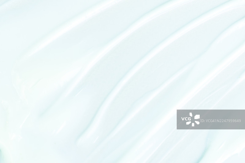 柔和的薄荷蓝抽象纹理，带有奶油光泽、光滑的褶皱和流动的漩涡，适用于背景设计、艺术和创意项目。美容护肤品概念。图片素材