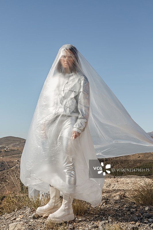 身着银色服装、佩戴未来感眼镜的年轻亚洲女性，置身于阿尔梅里亚半透明的塑料之中图片素材