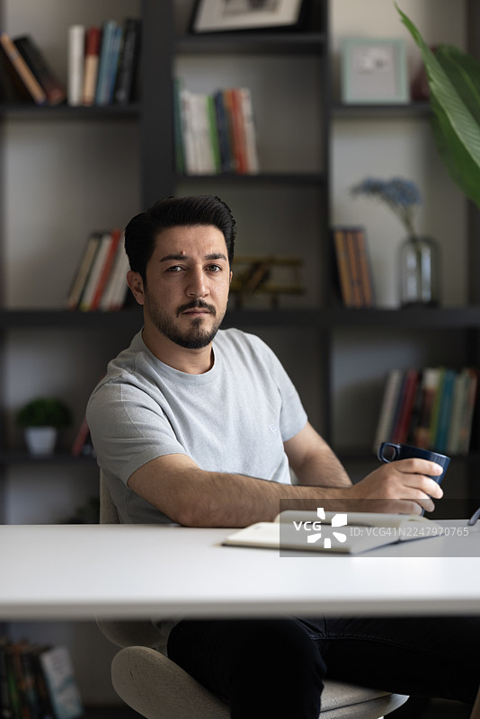 男人在书桌前写笔记本图片素材