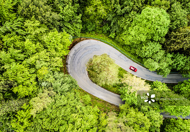 无人机视角下的乡村公路穿过森林图片素材