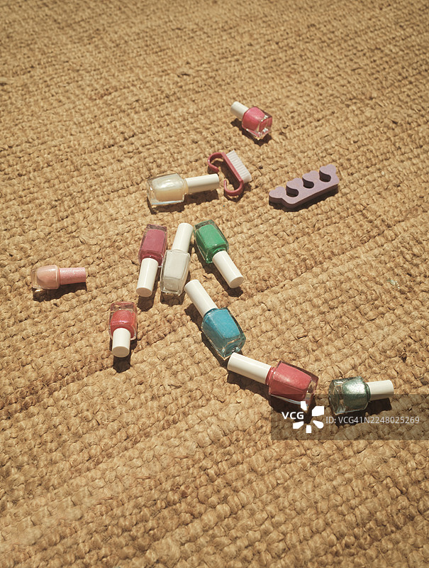 地毯上的指甲油瓶、分趾器和刷子图片素材