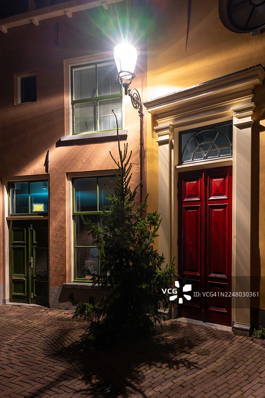 老房子前方的圣诞树和路灯图片素材