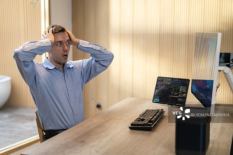因网络诈骗导致电脑系统被黑客入侵，男子显得担忧且震惊，压力重重图片素材