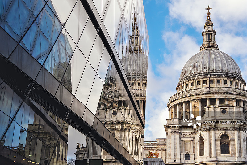 圣保罗大教堂的圆顶及其在现代玻璃建筑中的倒影图片素材