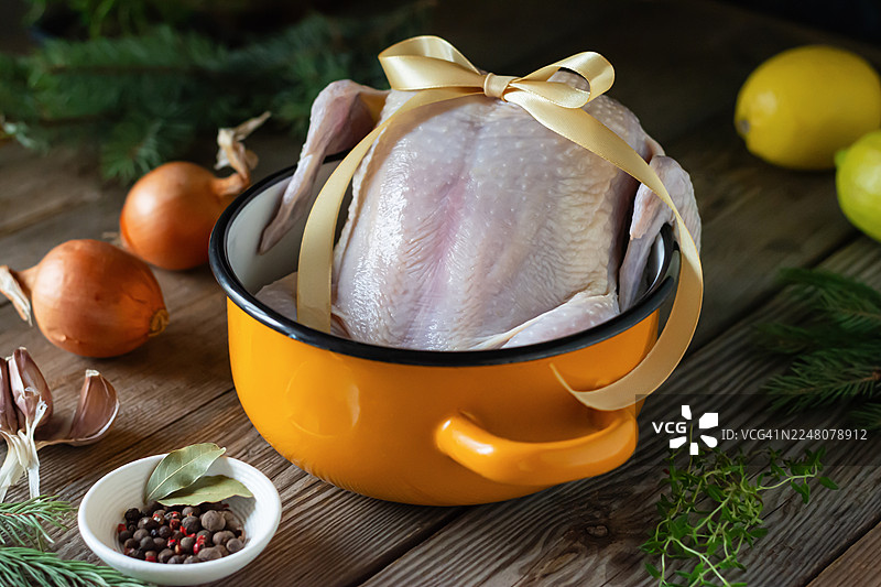 锅中用于熬汤的生鸡肉，在木质背景上烘烤图片素材
