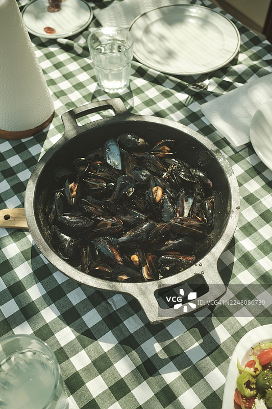 野餐桌上的铸铁锅蒸贻贝图片素材
