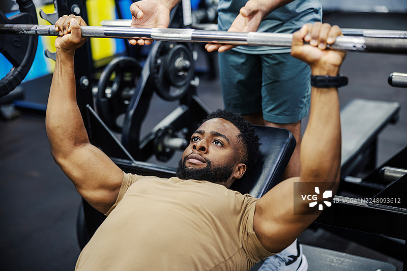 男人与私人教练一起训练，举着杠铃图片素材