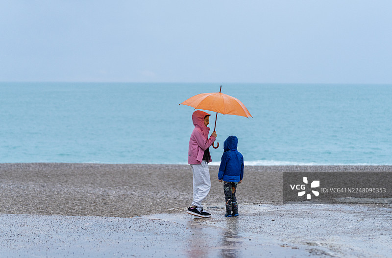 安塔利亚孔亚阿尔蒂海岸雨天撑橘色雨伞行走图片素材