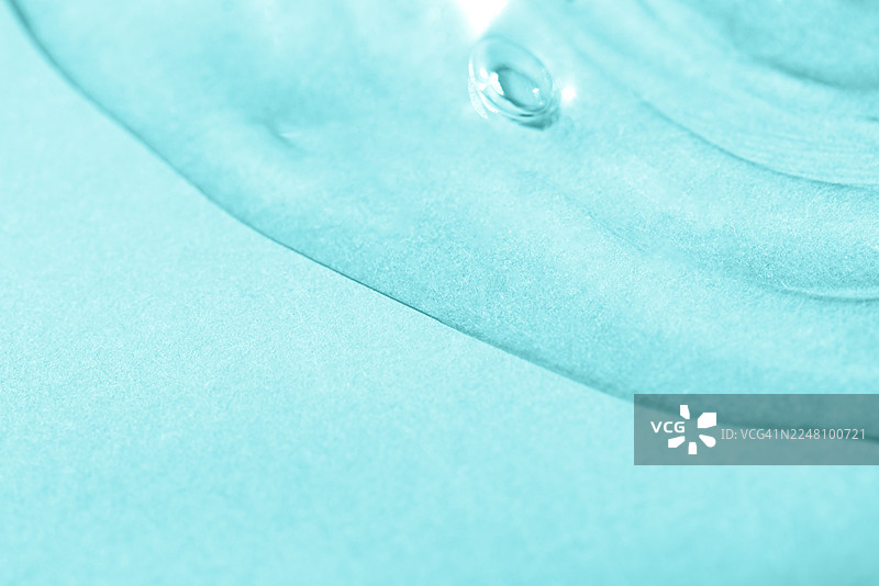 抽象纹理。液体凝胶化妆品。蓝色背景。图片素材