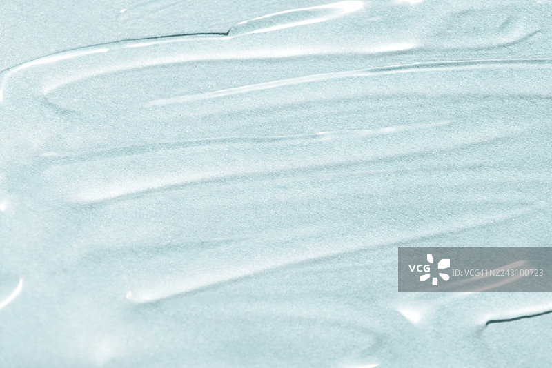 抽象纹理。液体凝胶化妆品。蓝色背景。图片素材