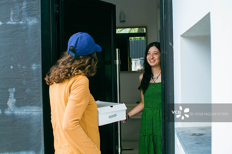 送货员在门口将包裹递给满意的顾客图片素材