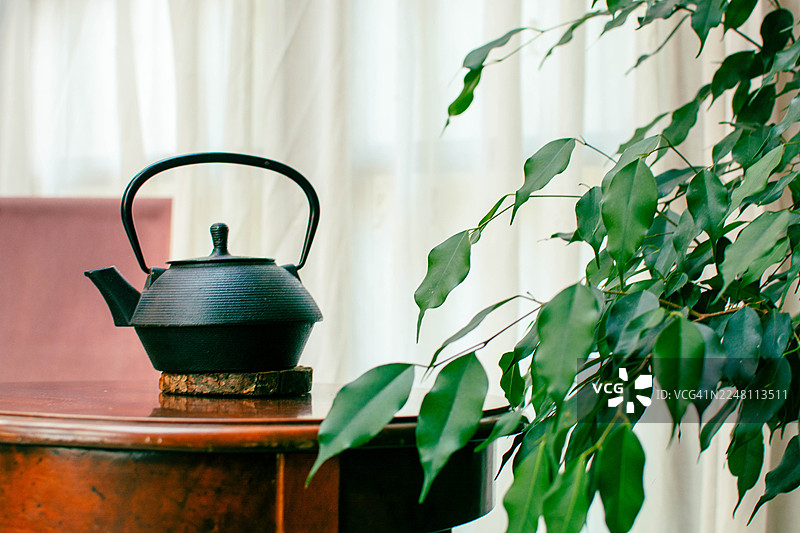 古朴的铸铁茶壶放在乡村风格的木桌上图片素材