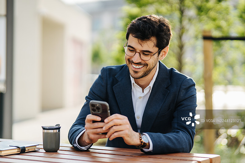 商人面带微笑在户外使用手机工作图片素材