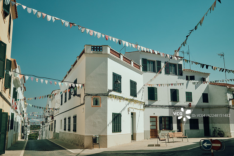 阳光下，装饰着节日彩带的传统西班牙街道图片素材