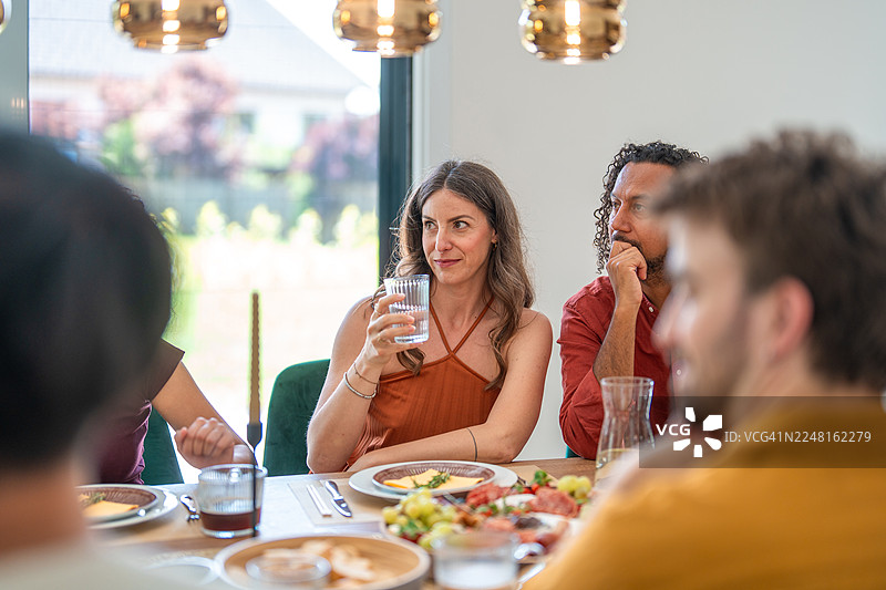 阳光明媚的现代餐厅里，年轻的朋友们正在享用便餐。图片素材