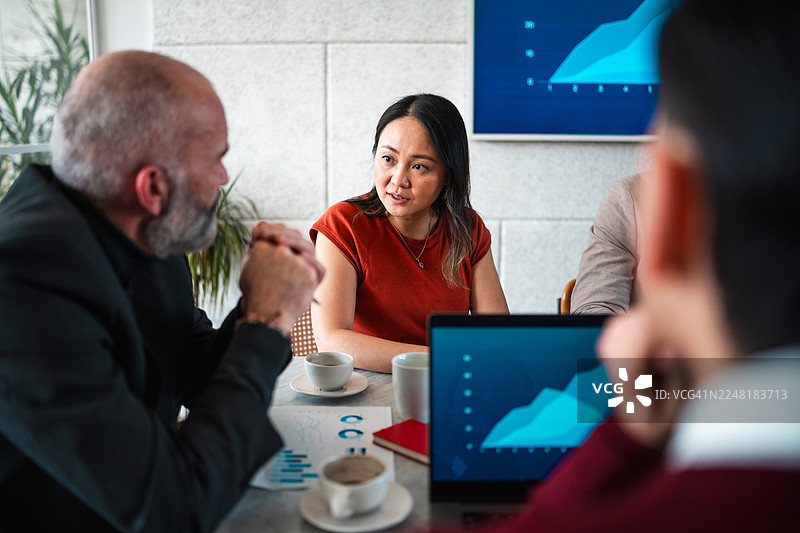 多元化的商业团队在现代会议室讨论战略目标，背景有分析图表图片素材