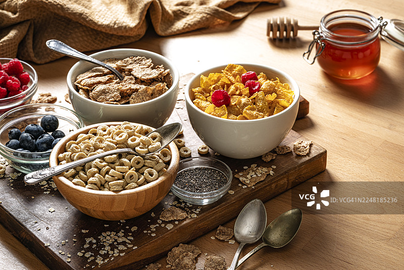 餐桌上的早餐麦片。碗里盛满了健康的杂粮麦片、浆果和奇亚籽，富含膳食纤维，有益于消化系统和肠道健康。图片素材