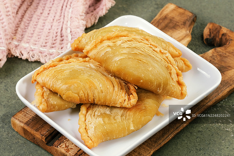 新鲜出炉的咖喱角摆放在白板上图片素材