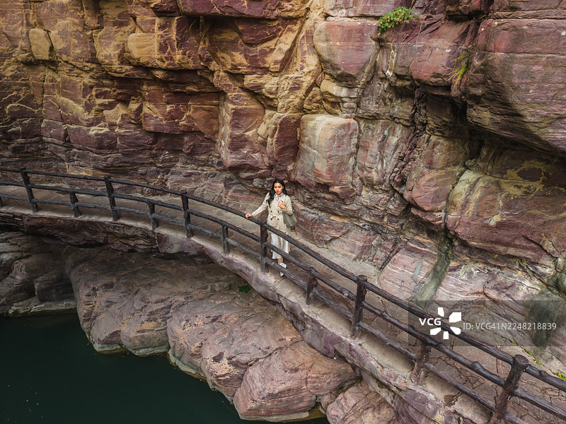 女子在峡谷的悬崖小径上行走图片素材