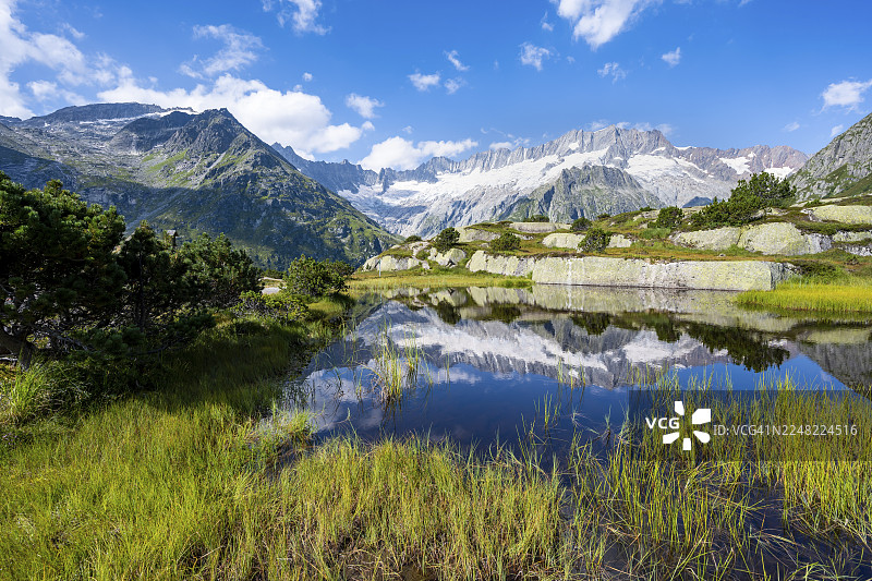 瑞士乌里州戈申嫩阿尔普的莫尔湖(Moorsee)倒映着达马斯托克峰(Dammastock)和达马斯冰川(Damma Glacier)的美丽山景图片素材