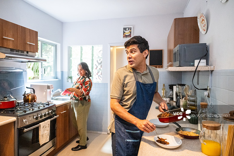 一对成熟的夫妇在厨房里一起做饭图片素材