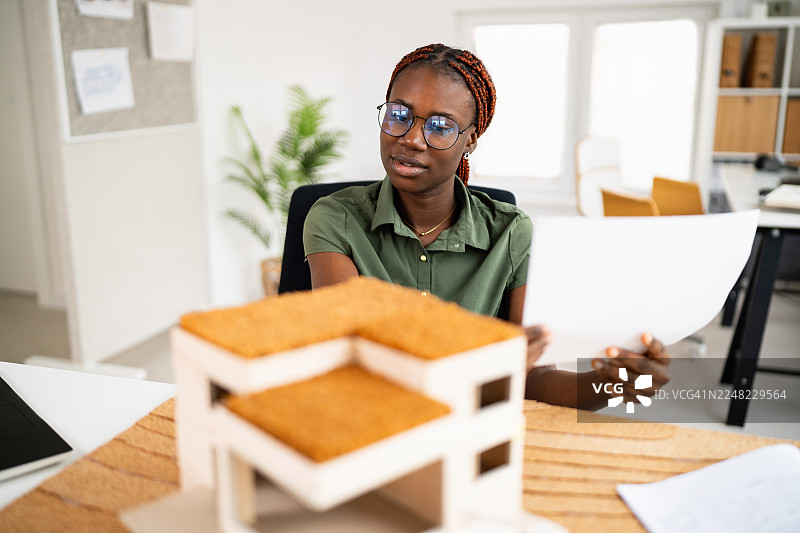 年轻的黑人建筑师在现代办公室审阅建筑图纸图片素材