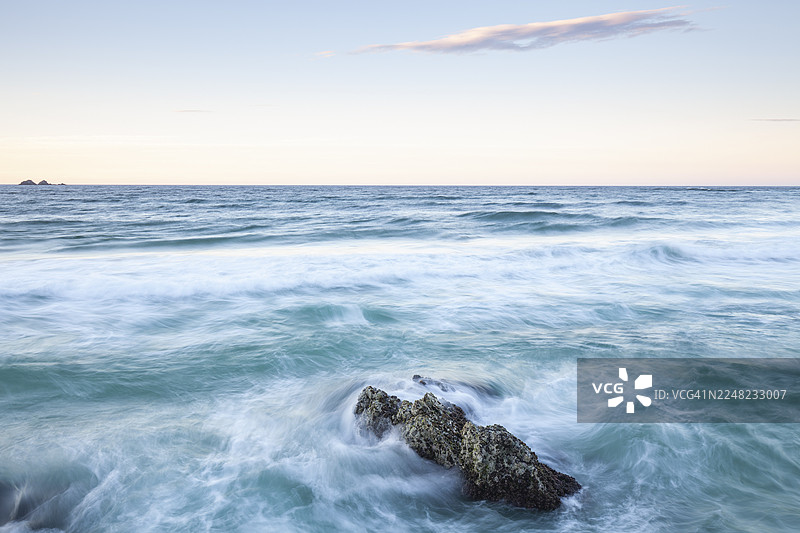 从“隘口”望去：前景是岩石和海浪，背景是澳大利亚拜伦湾的恩古恩古利朱利安岩石自然保护区。图片素材