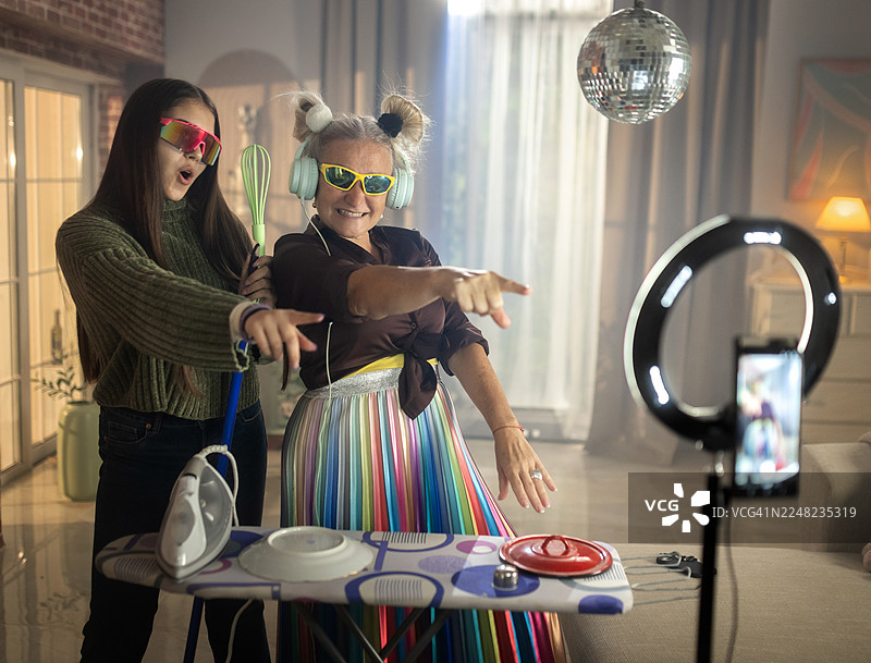 祖母和孙女在家一起录制有趣的抖音挑战，扮演DJ图片素材
