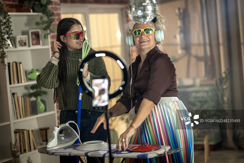 奶奶和孙女在家录制有趣的抖音挑战，扮演DJ图片素材
