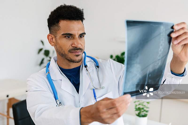 年轻成年男性医生在诊所查看X光片图片素材